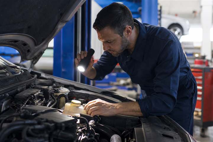 Mecânico revisando motor de veículo